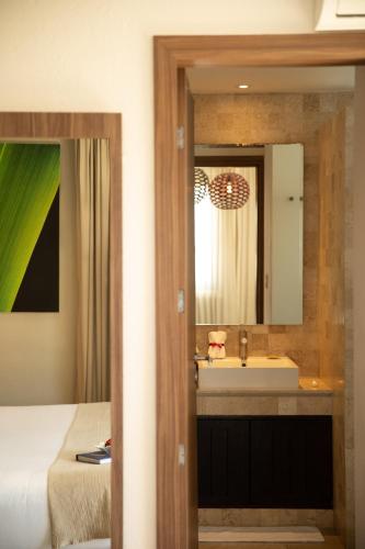 ein Badezimmer mit Waschbecken und Spiegel in der Unterkunft Ilo Rojo Hotel Boutique in San Miguel de Allende