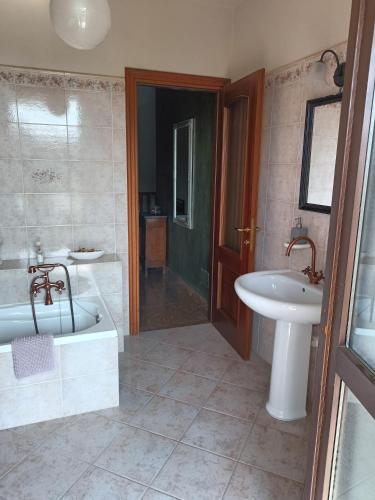 a bathroom with a tub and a sink and a bath tub at Casa Vicino in Carrù