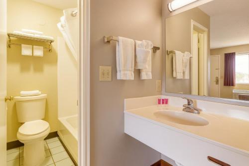 a bathroom with a sink and a toilet and a mirror at MHO Hotel Eloy Casa Grande Near I-10 in Eloy