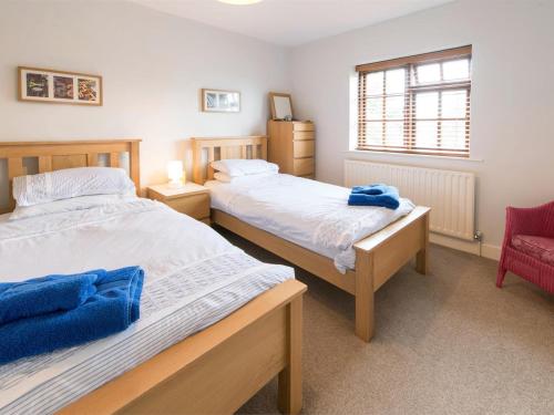 a bedroom with two beds and a red chair at 3 Bed in York oc-hh015 in Tockwith