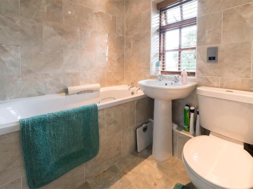 a bathroom with a toilet and a sink and a bath tub at 3 Bed in York oc-hh015 in Tockwith