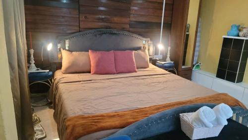 a bedroom with a large bed with pink pillows at Comfort Suites - Studio Two in La Fargue