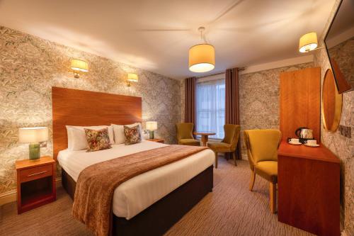 ein Hotelzimmer mit Bett, Tisch und Stühlen in der Unterkunft Castle Hotel in Dublin