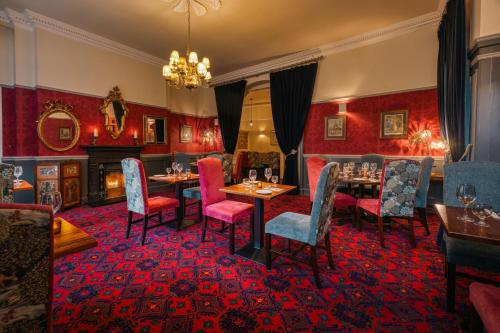 ein Esszimmer mit Tischen und Stühlen sowie einem Kamin in der Unterkunft Castle Hotel in Dublin