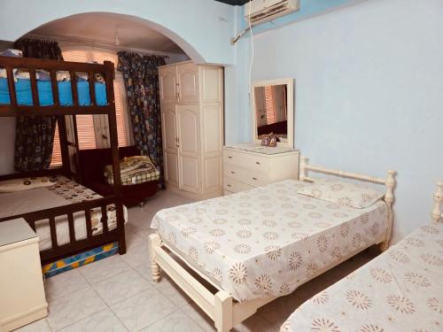 a bedroom with two bunk beds and a mirror at casabianca north coast chalet code 20 in Borg El Arab