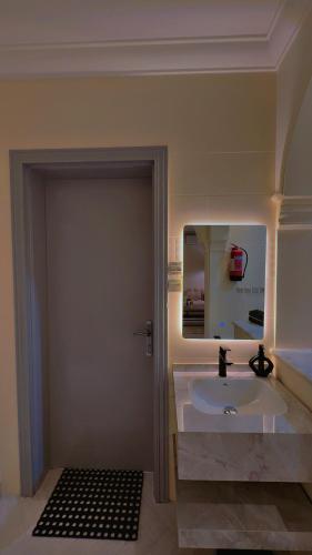 a bathroom with a sink and a mirror at شقة سُبات الفندقية الفاخرة in Buraydah