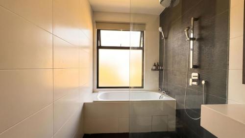 a bathroom with a bath tub and a window at Suasana JB Central by TPL in Johor Bahru