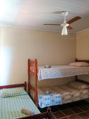 two bunk beds in a room with a ceiling fan at Apto Centro de Búzios - 2 Quartos - Ar-condicionado in Búzios