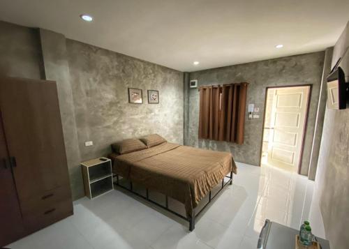 a bedroom with a bed and a door in it at 4Hearts Hotel in Suratthani