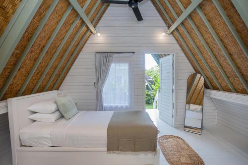 a bedroom with a large bed in a room at D'Yuki Huts Lembongan in Nusa Lembongan
