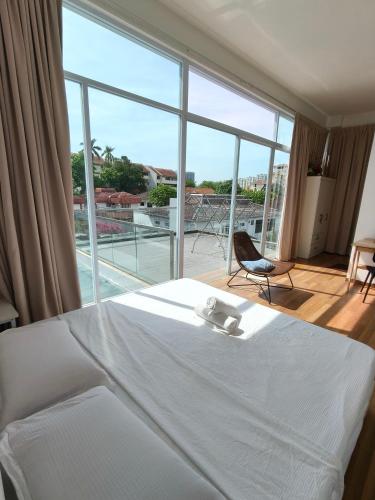a bedroom with a white bed and a large window at Penang Gelugor Landed House 4Rooms 3 Bathrooms in Gelugor
