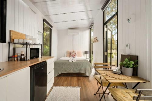 a bedroom in a tiny house with a bed at Halls Haven Tiny House 1 by Tiny Away in Halls Gap