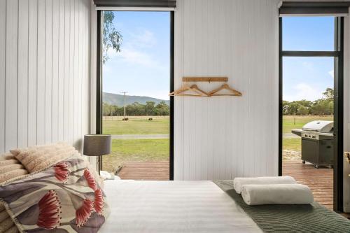 a bedroom with a bed and a large window at Halls Haven Tiny House 1 by Tiny Away in Halls Gap