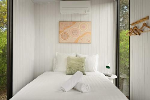 a bedroom with a large white bed and a window at Halls Haven Tiny House 2 by Tiny Away in Halls Gap
