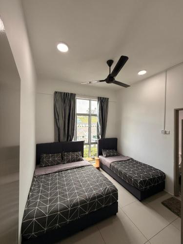 a bedroom with two beds and a ceiling fan at Peace Homestay 2 in Brinchang