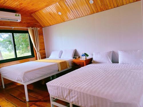 a room with two beds and a window at Retreat Bungalow in Phong Nha