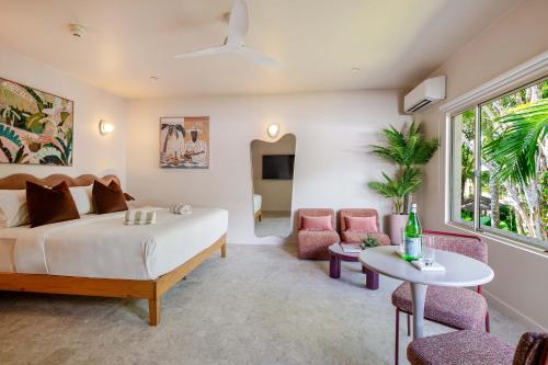 a bedroom with a bed and a table and chairs at CASA AMELIA - Boutique Studio in Port Douglas