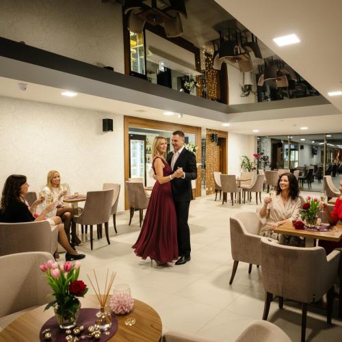 a man and woman standing in a restaurant at TeoDorka Med & SPA in Ciechocinek