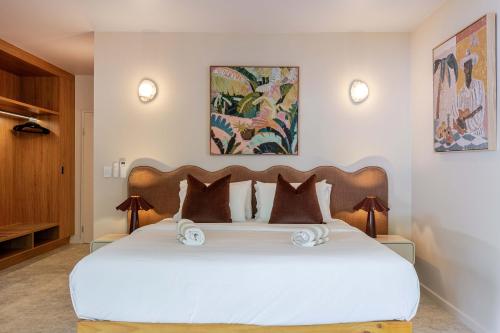 a bedroom with a large white bed with two pillows at CASA AMELIA - Boutique Studio in Port Douglas