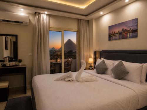 a hotel room with a bed with a swan on it at Arte Pyramids Hotel in Cairo