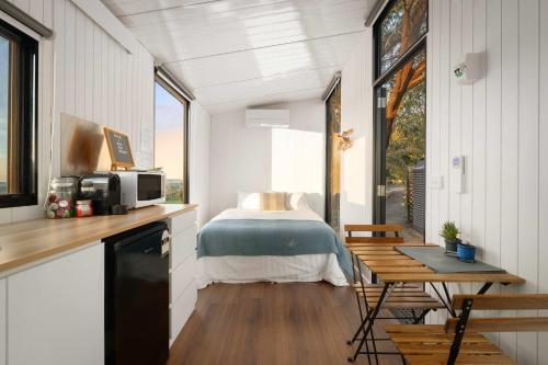 a bedroom in a tiny house with a bed at Nichol Road Hideaway at Annies Retreat by Tiny Away in Yackandandah