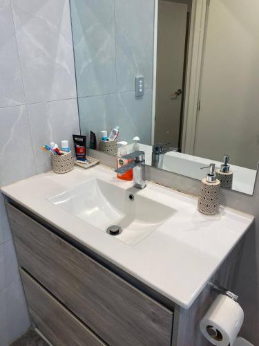 a bathroom with a white sink and a mirror at 1 Spacious bedroom available in Auckland