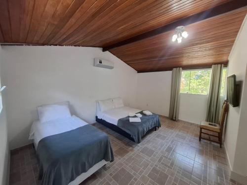 a bedroom with two beds and a wooden ceiling at Pousada Colibris da Barra da Tijuca in Rio de Janeiro