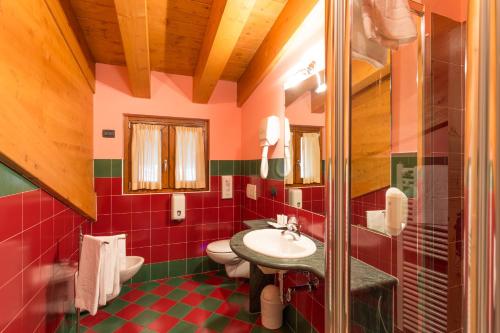 a bathroom with two toilets and a sink at Hotel Arisch in Aprica