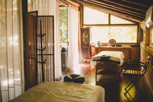 a bedroom with a bed and a desk and a window at Alua Camburi in Camburi