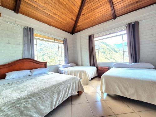 a bedroom with two beds and a large window at Luxury Quinta con Jacuzzi - Sauna - BBQ in Cusúa