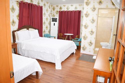 a hotel room with two beds and a toilet at Koa Guest House in Angeles