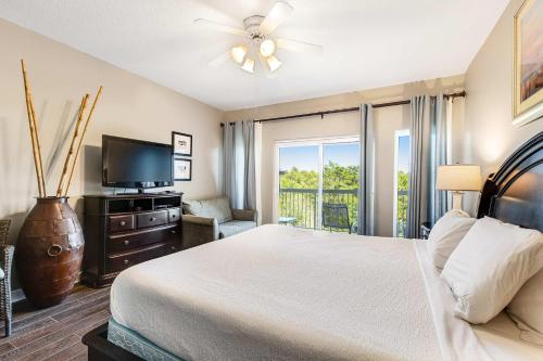 a bedroom with a bed and a flat screen tv at Resort Studio with Nature Preserve Views in Destin