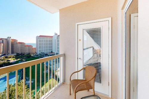 a balcony with a chair and a view of the city at TOPS'L Summit 1013 in Destin