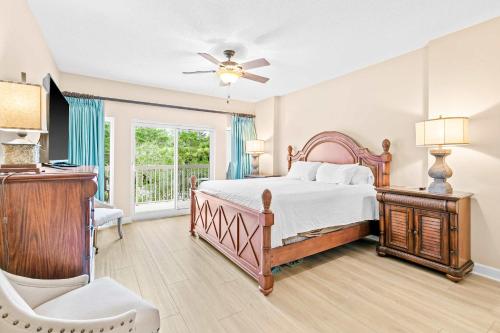 a bedroom with a bed and a chair and a window at TOPS'L Summit 207A in Destin