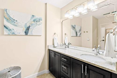 a bathroom with a sink and a large mirror at TOPS'L Summit 207A in Destin