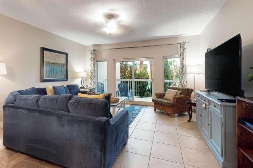 a living room with a couch and a flat screen tv at TOPS'L Summit 210 in Destin