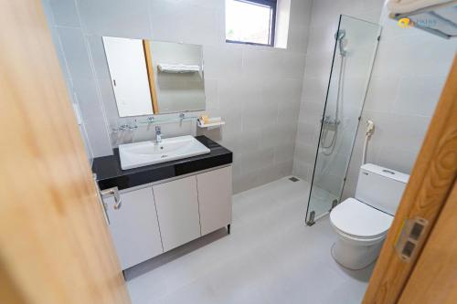 a bathroom with a toilet and a sink and a shower at Phu Hai Apartment in Dong Hoi