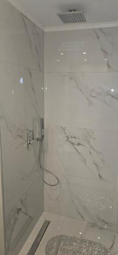 a bathroom with a shower with white marble at Alora Cosy Suite in Kefalos