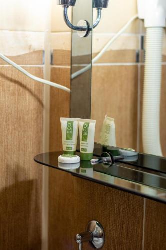a bathroom counter with two tubes of toothpaste on it at Elit Garden Hotel in Kamianets-Podilskyi