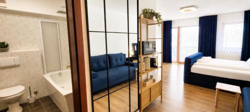 a bathroom with a blue couch in a room at KOMM - Panoramablick - Balkon - Küche - Parkplatz in Suhl