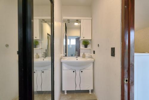 a bathroom with two sinks and a mirror at Roy Arias Suites & Residences in Santo Domingo