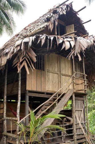 an old hut with a thatched roof on top of it at Coco House - Playa La Barra in Buenaventura