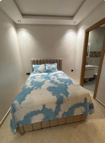 a bedroom with a blue and white comforter on a bed at Chambre avec WC privée pr 1p dans un appart partagé avec 1p in Sidi Maarouf