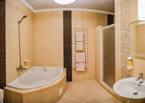 a bathroom with a tub and a sink at Golden Palace in Dubove
