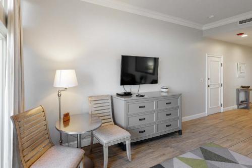 a living room with a tv and a table and chairs at TOPS'L Summit 1108A in Destin