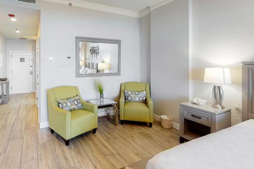 a hotel room with two chairs and a table and a bed at TOPS'L Summit 1108A in Destin