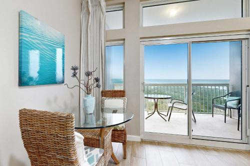 a dining room with a glass table and a balcony at Top-Floor Studio with Ocean Views and Pool in Destin