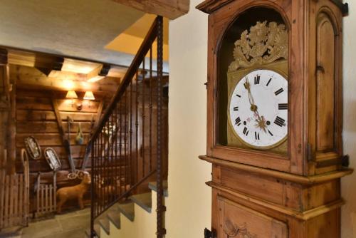 a wooden grandfather clock sitting next to a staircase at Hotel La Rouja in Champoluc