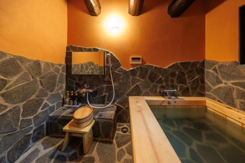 a bathroom with a swimming pool and a tub with a toilet at Yumoto Choza in Takayama