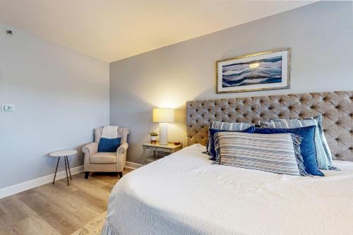 a bedroom with a large bed and a chair at 4th-Floor Condo with Shared Pool and WiFi in Destin